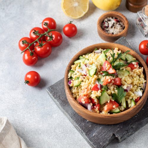 Salad with bulgur, tomatoes, cucumbers and parsley. Tabouleh dish. Oriental cuisine. High quality photo
